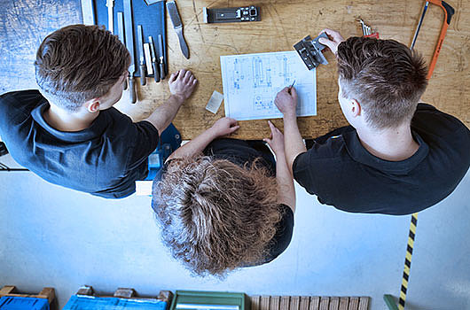 Three interns at a workbench